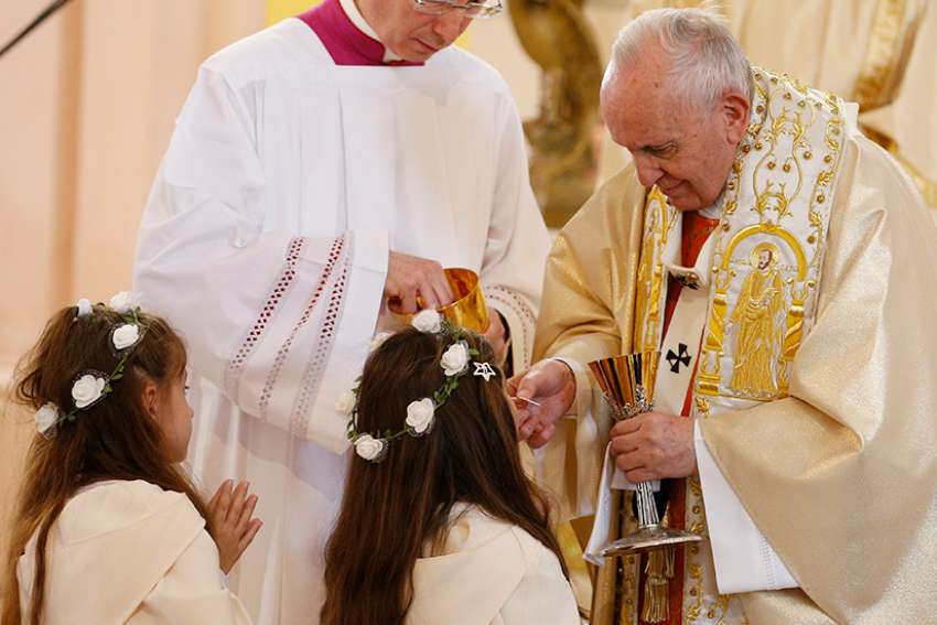 After offering instruction, Pope gives first Communion to 245 children