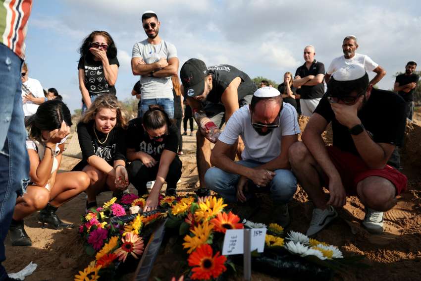 Pilgrims pray as Israeli families mourn loved ones