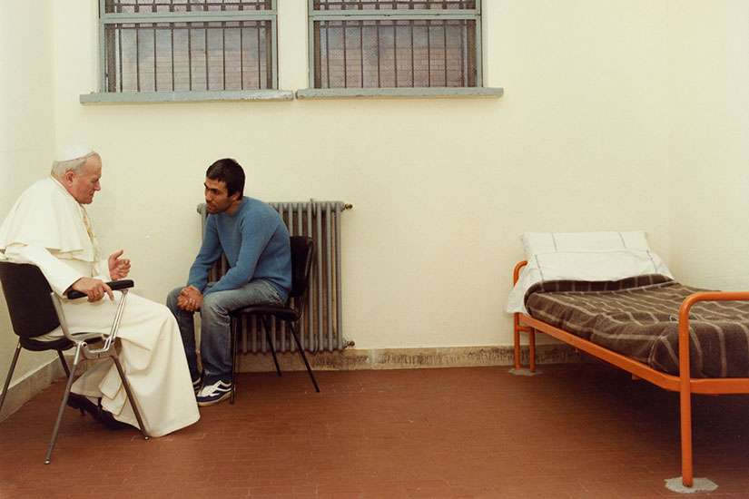 Man who tried to kill John Paul II takes flowers to his tomb