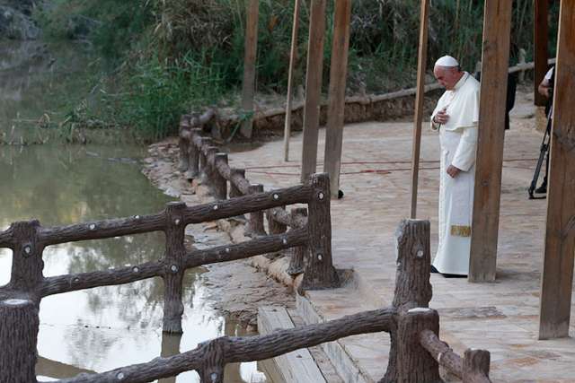 At River Jordan, pope meets suffering, speaks against arms trade